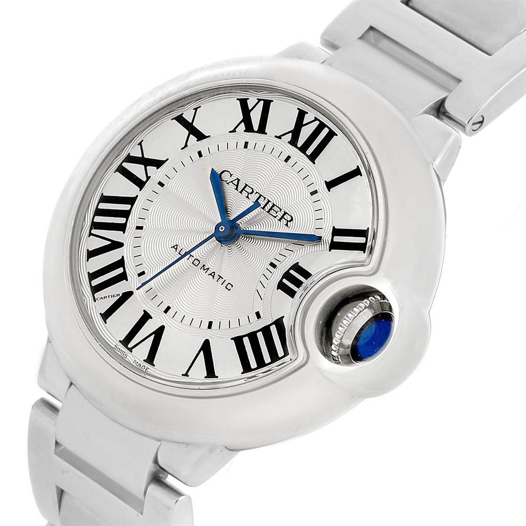 The image shows a close-up, angled view of the Cartier Ballon Bleu W6920046 Women
s Stainless Steel Silver Dial W6920046 Women
s Stainless Steel Silver Dial watch, highlighting the dial, Roman numerals, and crown with a blue cabochon.