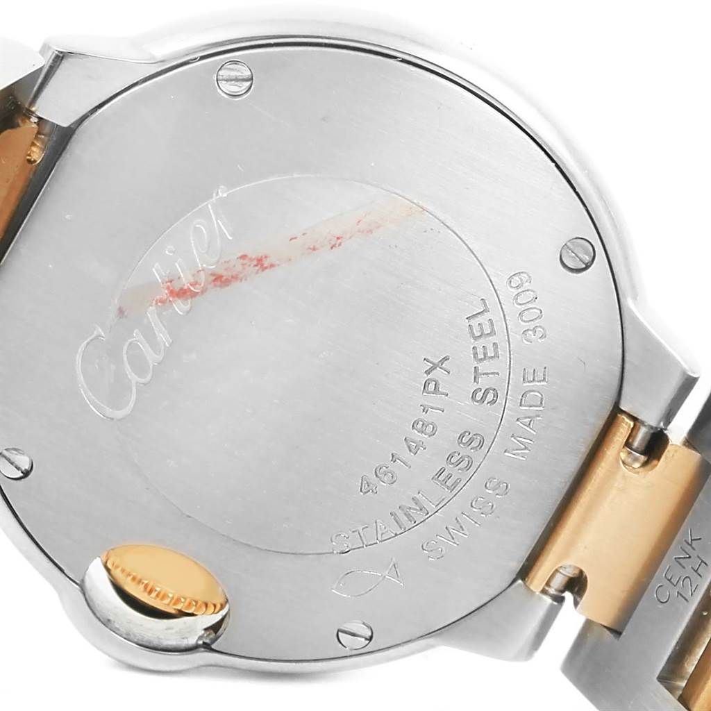The image shows the backcase and part of the bracelet of a Ballon Bleu by Cartier watch, highlighting its engraving and screws.