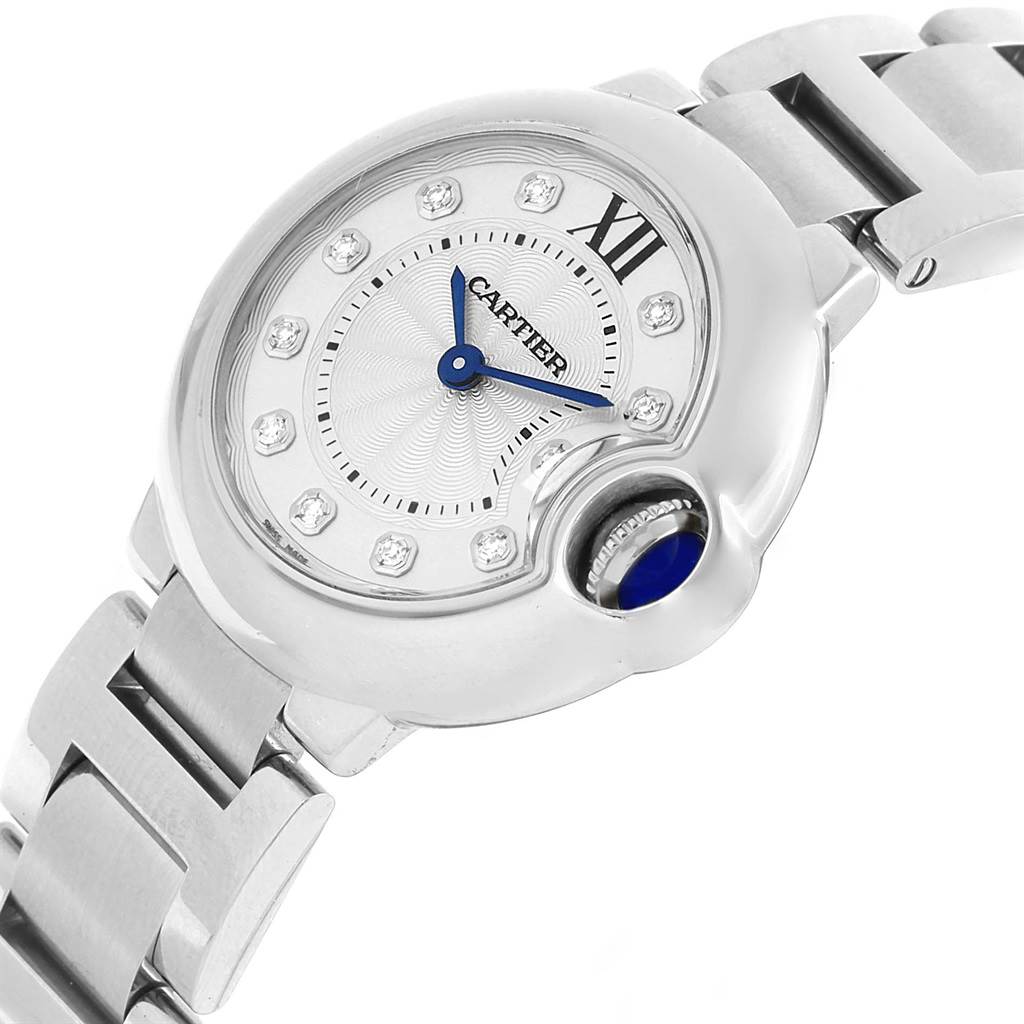 The image shows a Cartier Ballon Bleu WE902073 Women
s Stainless Steel Silver Dial WE902073 Women
s Stainless Steel Silver Dial watch from an angled top-down perspective, highlighting its dial, crown, and part of the bracelet.