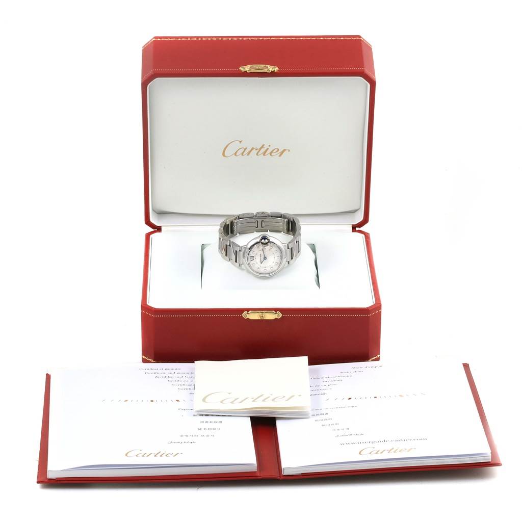 The image shows a Cartier Ballon Bleu WE902073 Women
s Stainless Steel Silver Dial WE902073 Women
s Stainless Steel Silver Dial watch in an open red box with documents displayed in front.