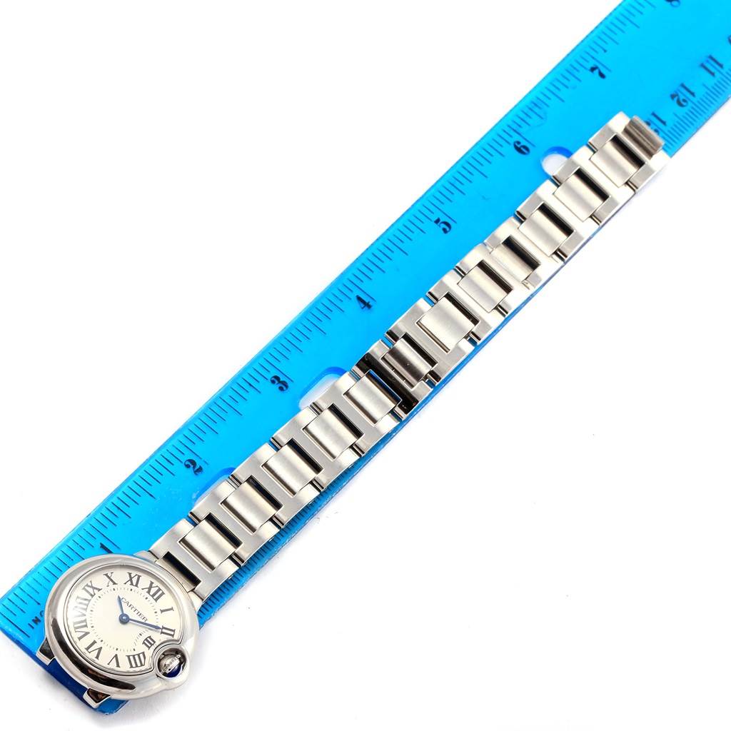 The image shows a top view of a Cartier Ballon Bleu W69010Z4 Women's Stainless Steel Silver Dial W69010Z4 Women's Stainless Steel Silver Dial watch with its band placed next to a blue ruler.