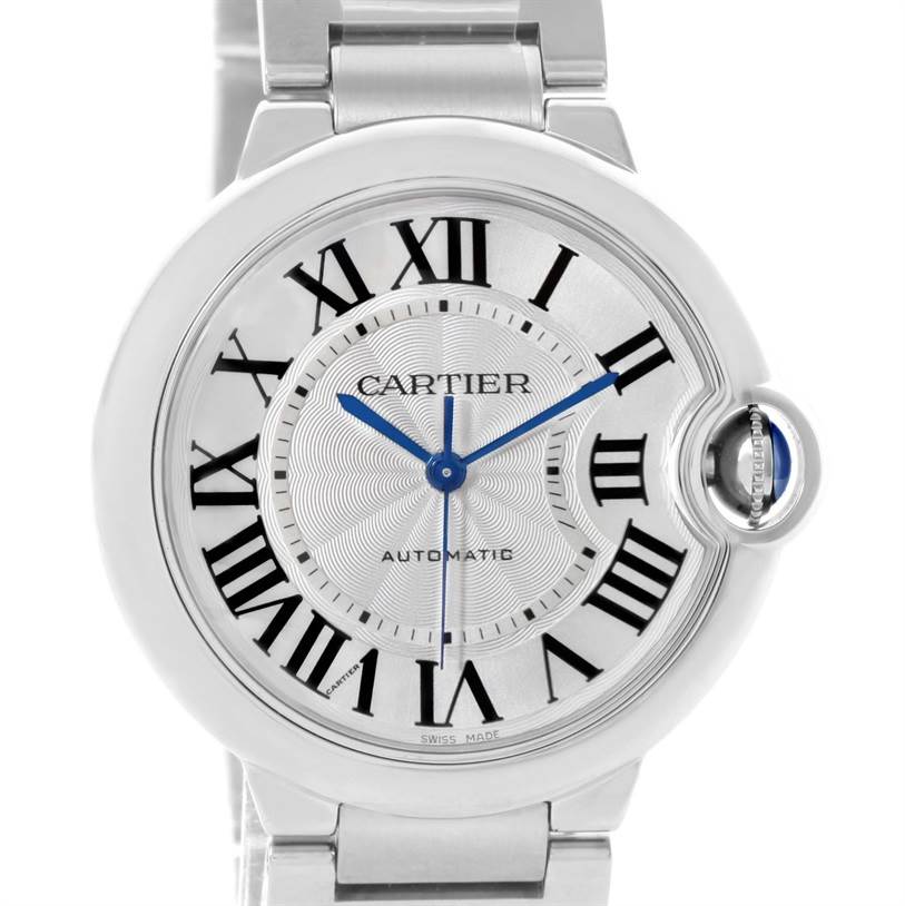The image shows a close-up of the Cartier Ballon Bleu W6920046 Women
s Stainless Steel Silver Dial W6920046 Women
s Stainless Steel Silver Dial watch face, highlighting its Roman numerals, blue hands, and unique crown.