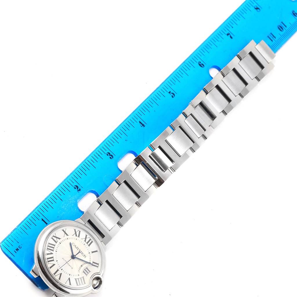 This image shows a Cartier Ballon Bleu W6920046 Women's Stainless Steel Silver Dial W6920046 Women's Stainless Steel Silver Dial watch positioned next to a ruler, focusing on the strap and part of the watch face.