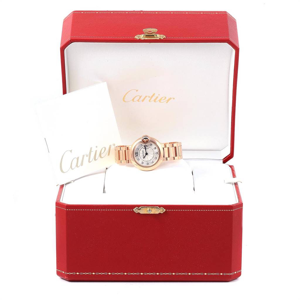 The Cartier Ballon Bleu WE902025 Women's Rose Gold Silver Dial WE902025 Women's Rose Gold Silver Dial watch is shown in an open red case with its instruction manual.