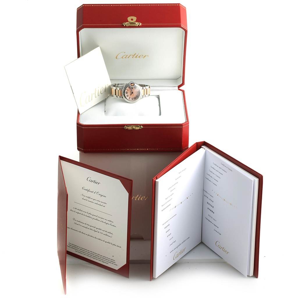 The image shows a Cartier Ballon Bleu W6920034 Women's Steel and Gold (two tone) Mother of Pearl Dial W6920034 Women's Steel and Gold (two tone) Mother of Pearl Dial watch in its open box, accompanied by certificates and manuals, also in red and white.