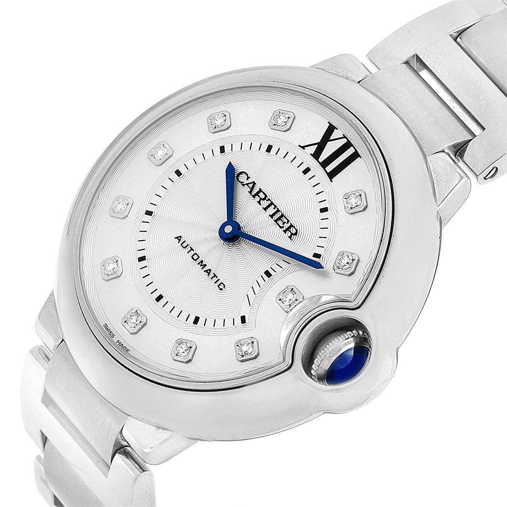 The image shows a close-up of the face and part of the bracelet of the Ballon Bleu model by Cartier, highlighting the blue hands and Roman numeral "III."