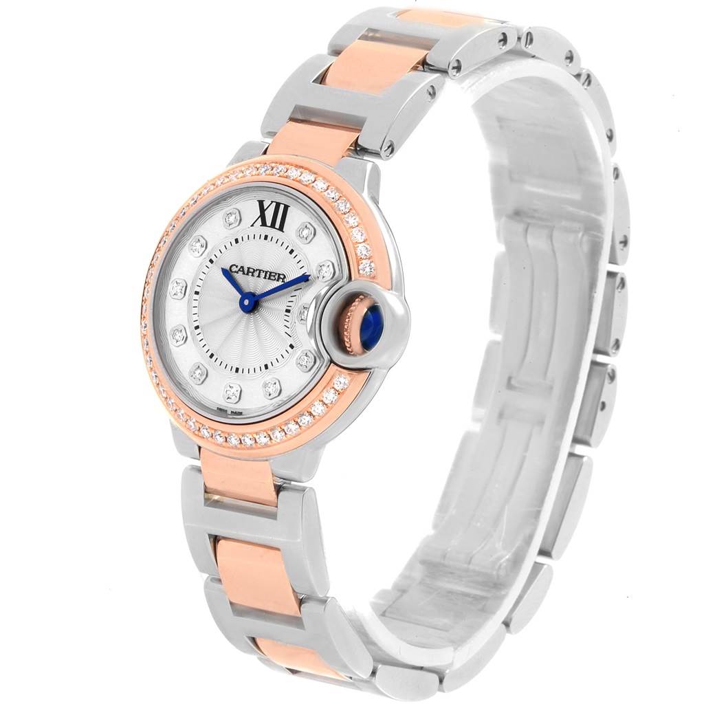 The image shows a Cartier Ballon Bleu WE902076 Women
s Steel and Gold (two tone) Silver Dial WE902076 Women
s Steel and Gold (two tone) Silver Dial watch at an angle displaying the face, bracelet, and crown.
