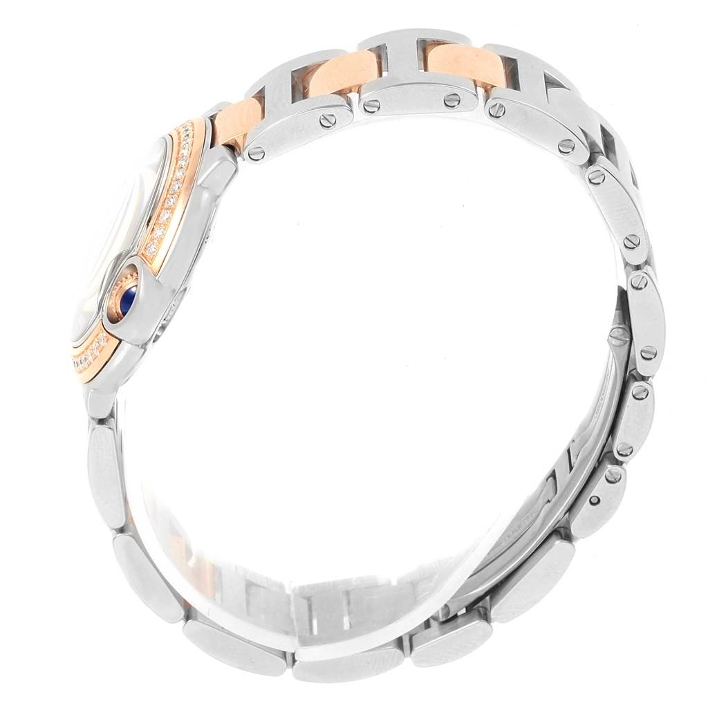 The image shows a side profile of the Cartier Ballon Bleu WE902076 Women
s Steel and Gold (two tone) Silver Dial WE902076 Women
s Steel and Gold (two tone) Silver Dial watch, highlighting its bracelet and crown.