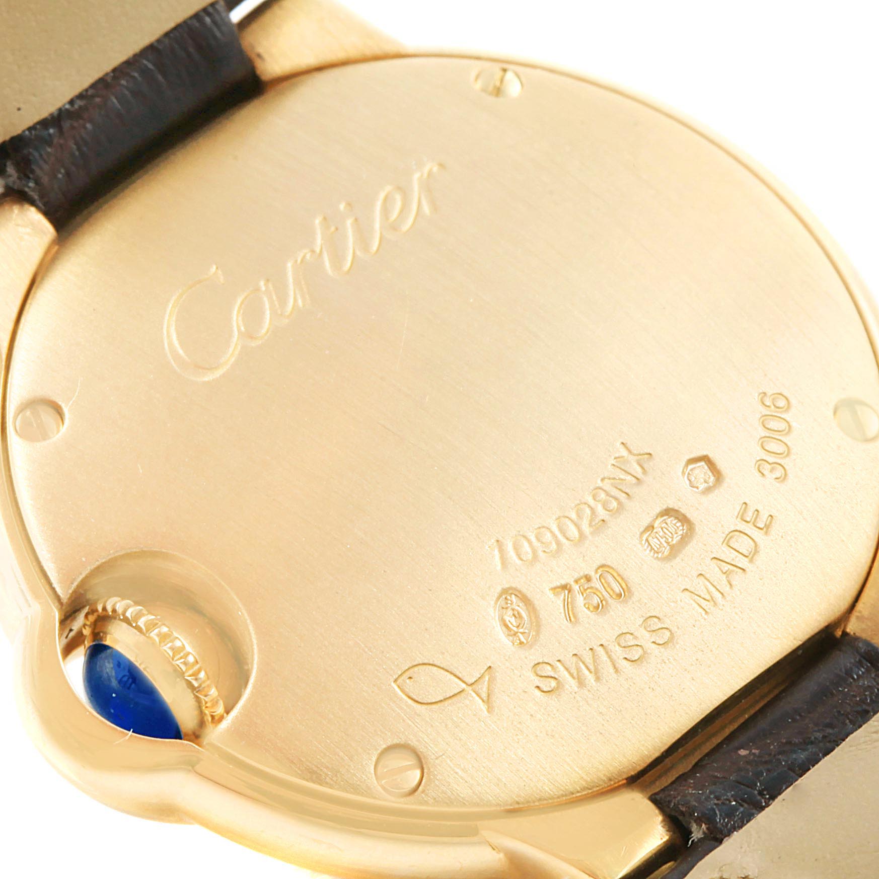 The image shows a close-up of the back case of a gold Cartier Ballon Bleu WE900151 Women's Yellow Gold Silver Dial WE900151 Women's Yellow Gold Silver Dial watch, detailing inscriptions and a glimpse of the crown.