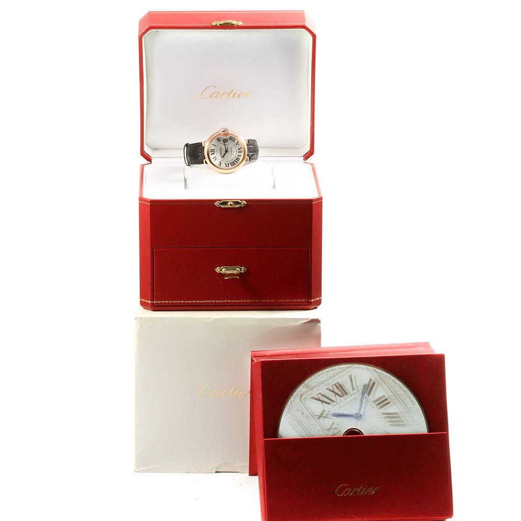 The image shows a Cartier Ballon Bleu WGBB0009 Men's Rose Gold Silver Dial WGBB0009 Men's Rose Gold Silver Dial watch in an open red box, with another Cartier box and booklet underneath.