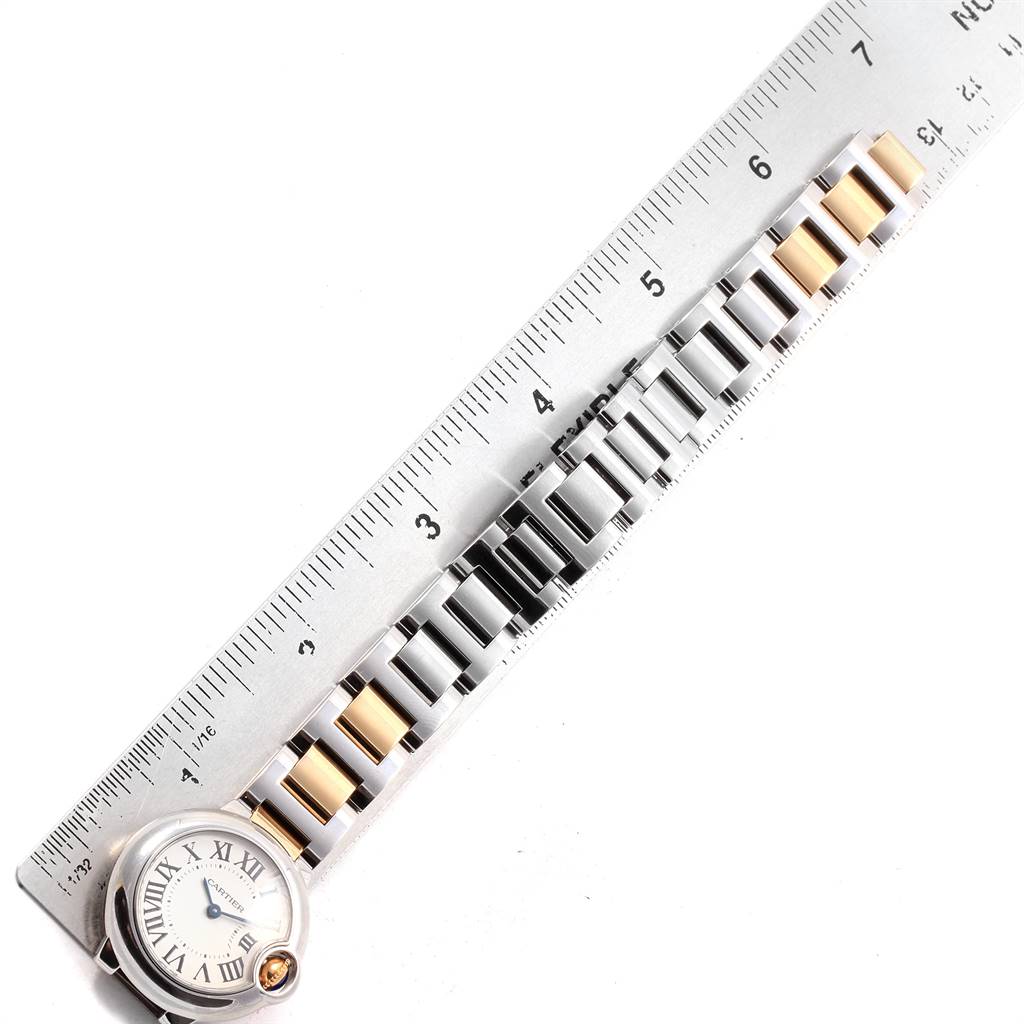 The image shows a Cartier Ballon Bleu W69007Z3 Women
s Stainless Steel Silver Dial W69007Z3 Women
s Stainless Steel Silver Dial watch positioned diagonally across a ruler, highlighting its metal and gold link bracelet.