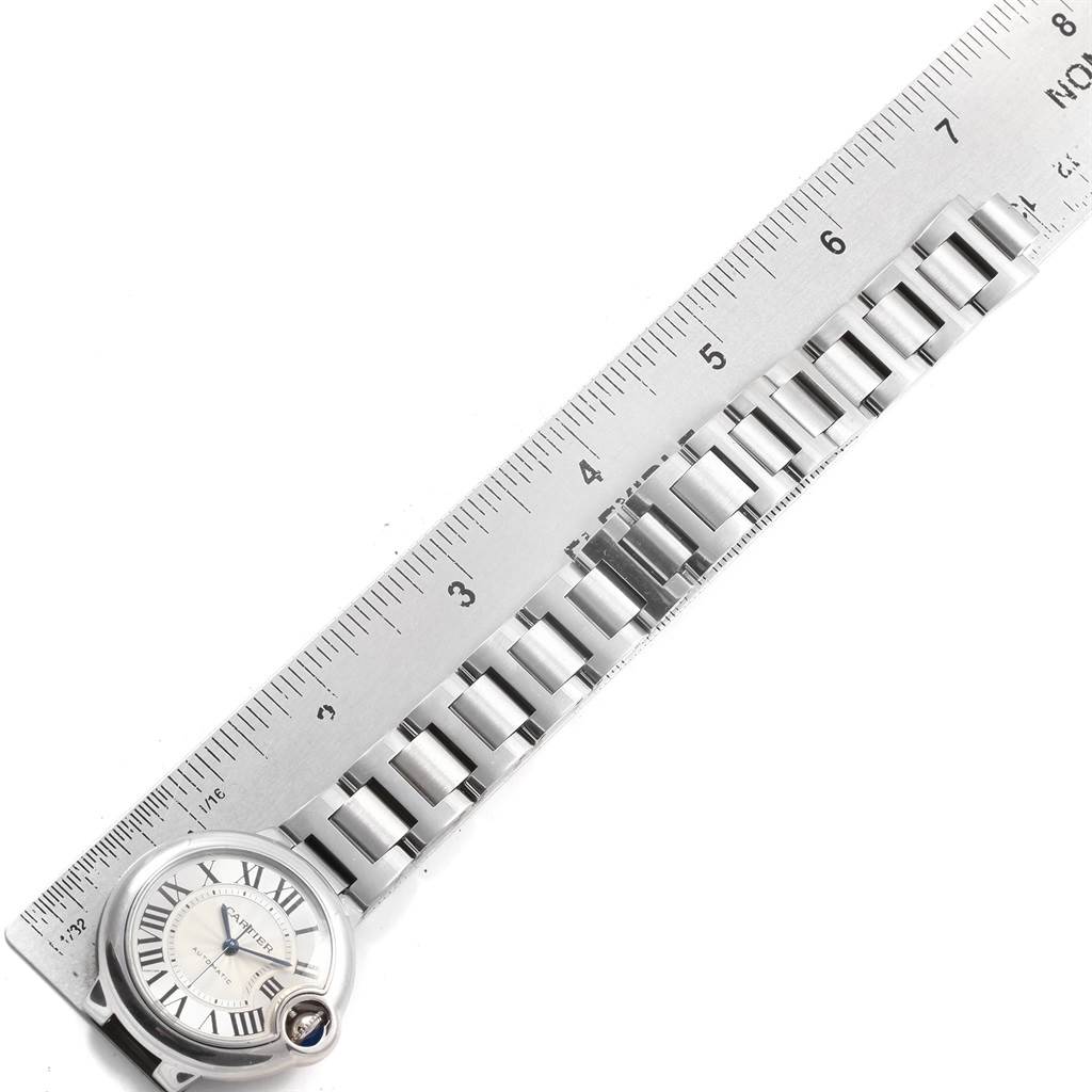 The image shows a Cartier Ballon Bleu W6920071 Women
s Stainless Steel Silver Dial W6920071 Women
s Stainless Steel Silver Dial watch placed next to a ruler, displaying the watch face and bracelet.
