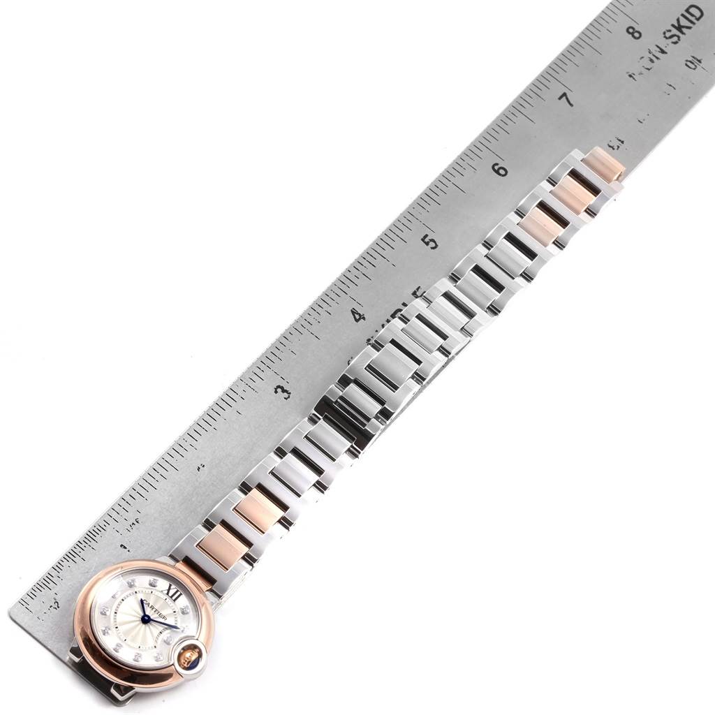The image shows the Ballon Bleu de Cartier watch and its metal bracelet beside a ruler, displayed from an overhead angle.