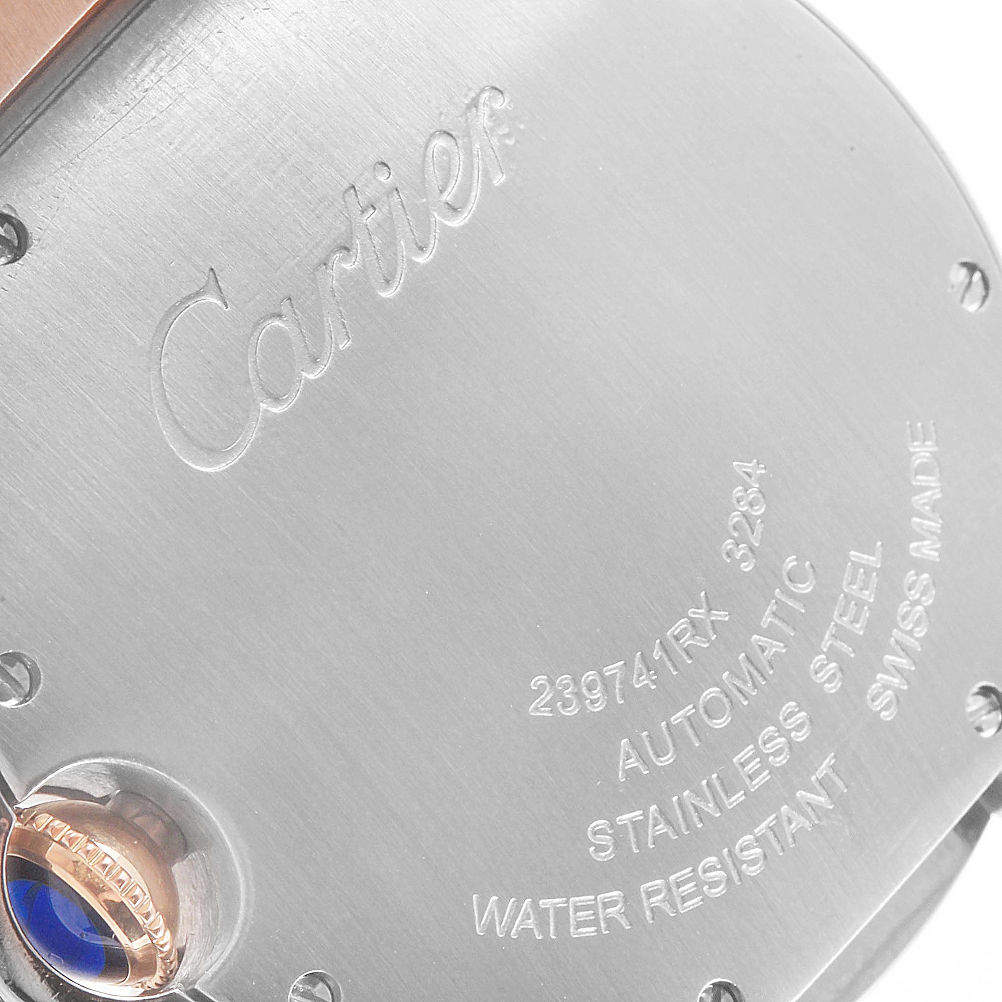 The image shows the back casing of a Cartier Ballon Bleu W2BB0011 Women's Steel and Gold (two tone) Mother of Pearl Dial W2BB0011 Women's Steel and Gold (two tone) Mother of Pearl Dial watch, highlighting the engraved details and part of the crown.