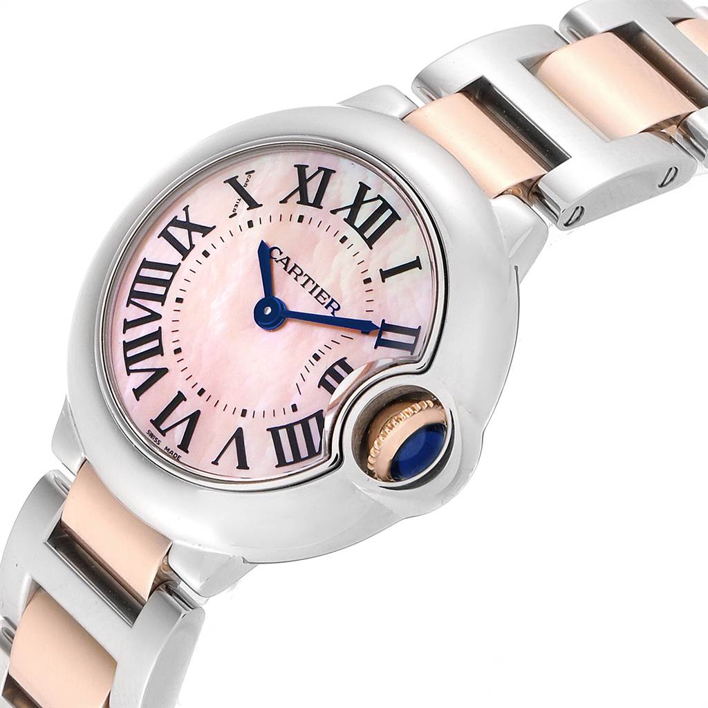 This image shows a close-up of a Cartier Ballon Bleu W6920034 Women's Steel and Gold (two tone) Mother of Pearl Dial W6920034 Women's Steel and Gold (two tone) Mother of Pearl Dial watch face and part of its metal and gold bracelet.