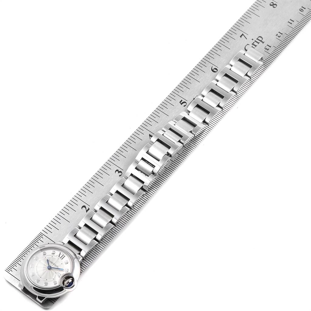 The image shows a side view of the Ballon Bleu watch by Cartier, emphasizing its face and bracelet alongside a ruler for scale.