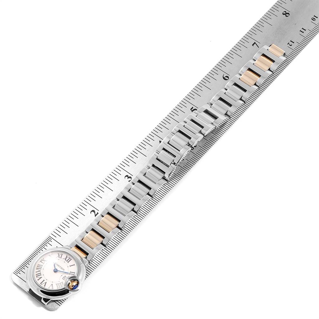 The image shows an overhead view of a Cartier Ballon Bleu W69007Z3 Women
s Stainless Steel Silver Dial W69007Z3 Women
s Stainless Steel Silver Dial watch with its metal and gold bracelet placed on a measuring scale.