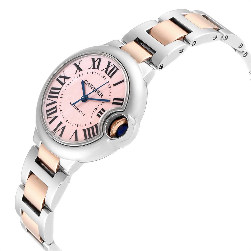 The image shows a side view of the Cartier Ballon Bleu W6920098 Women
s Steel and Gold (two tone) Mother of Pearl Dial W6920098 Women
s Steel and Gold (two tone) Mother of Pearl Dial watch, highlighting its pink dial, blue hands, and two-tone metal bracelet.