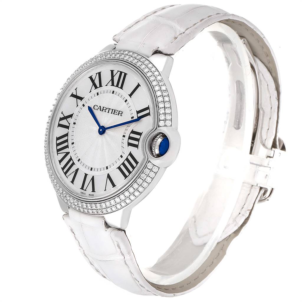 The image shows a Cartier Ballon Bleu WE902056 Women's White Gold Silver Dial WE902056 Women's White Gold Silver Dial watch from a front angle, displaying its face, diamond-encrusted bezel, and white strap.
