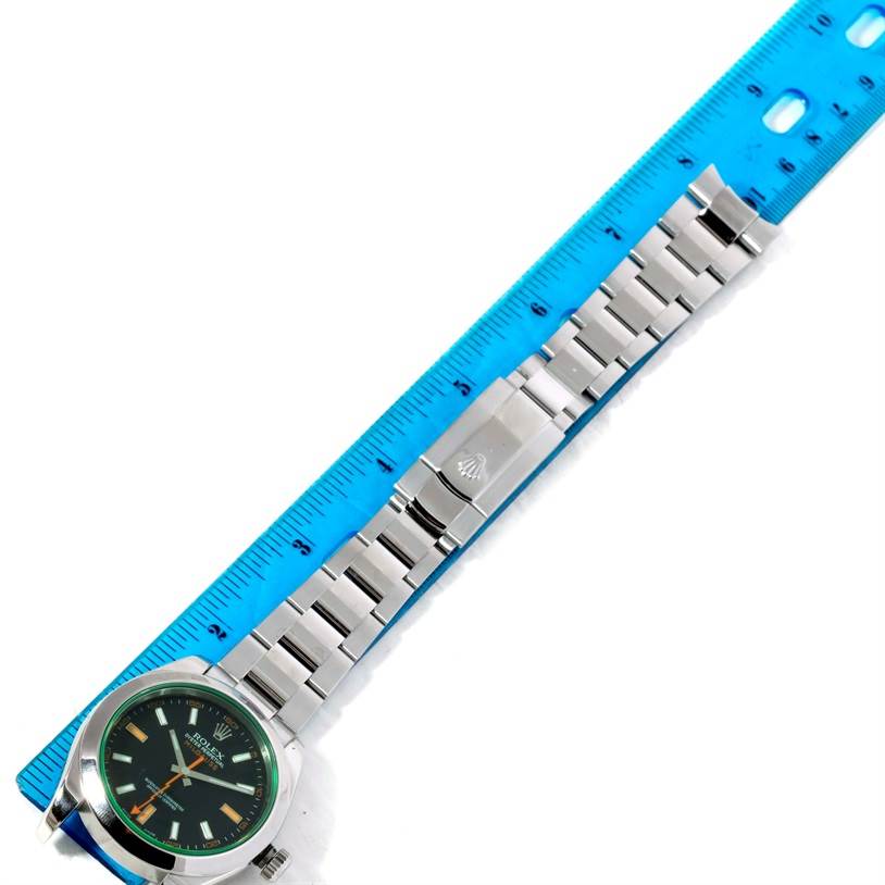 The image shows a Rolex Milgauss 116400V Men's Stainless Steel Black Dial 116400V Men's Stainless Steel Black Dial watch laid flat next to a ruler, displaying the face, bracelet, and clasp.