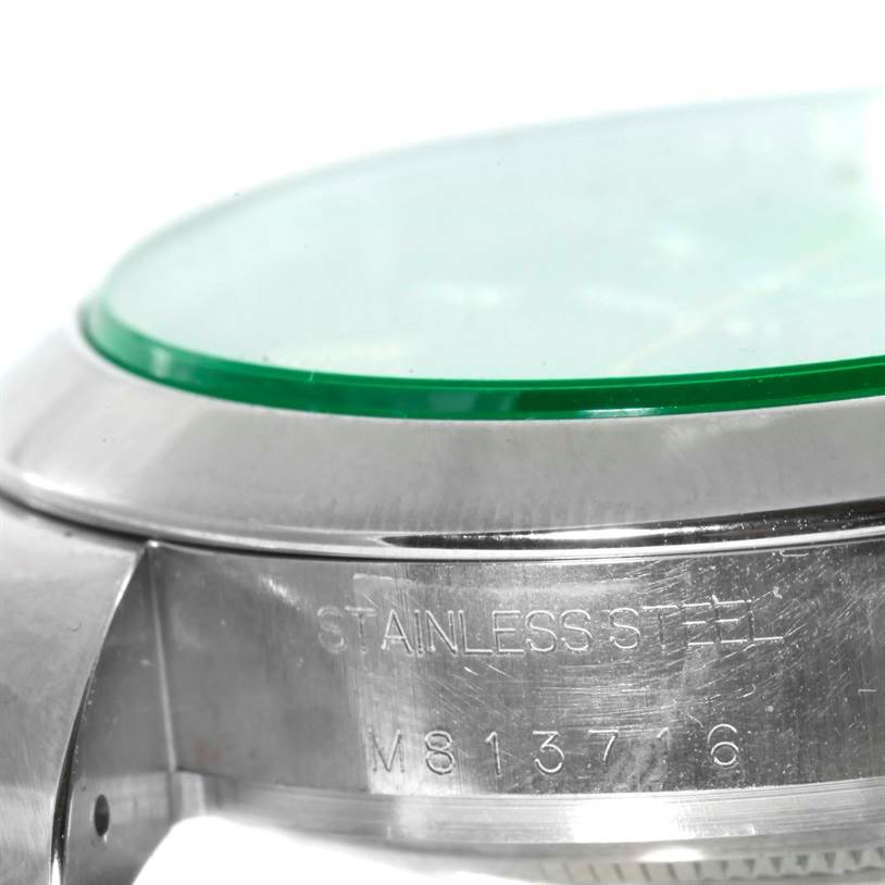 The image shows a close-up of the side of a Rolex Milgauss 116400V Men's Stainless Steel Black Dial 116400V Men's Stainless Steel Black Dial watch, focusing on its stainless steel case and the engraved serial number.