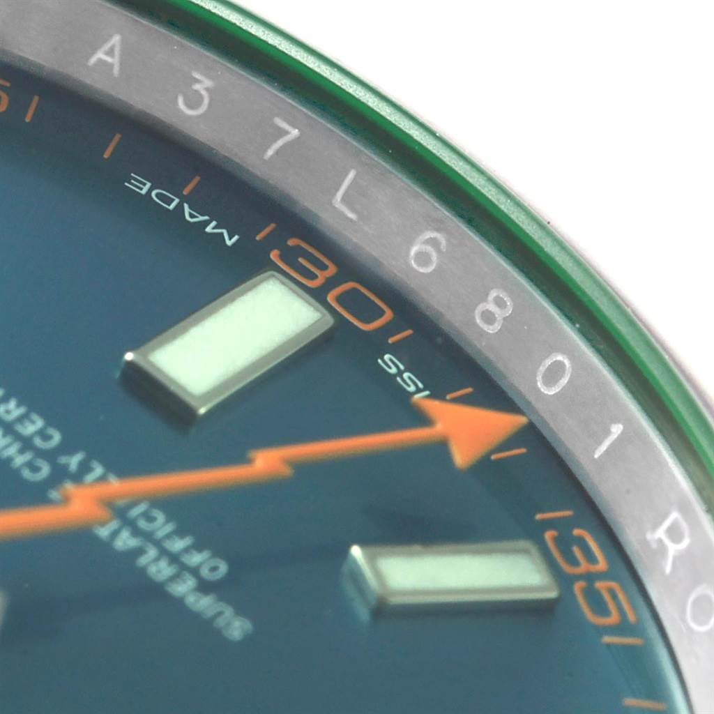 Close-up of the Rolex Milgauss 116400GV Men's Stainless Steel Blue Dial 116400GV Men's Stainless Steel Blue Dial watch showing part of the dial, orange minute markers, and the green-tinted edge of the crystal.