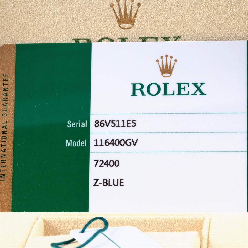 This image shows a close-up of a warranty card for a Rolex Milgauss 116400V Men's Stainless Steel Blue Dial 116400V Men's Stainless Steel Blue Dial model 116400GV, serial number 86V511E5, with a portion of the packaging.