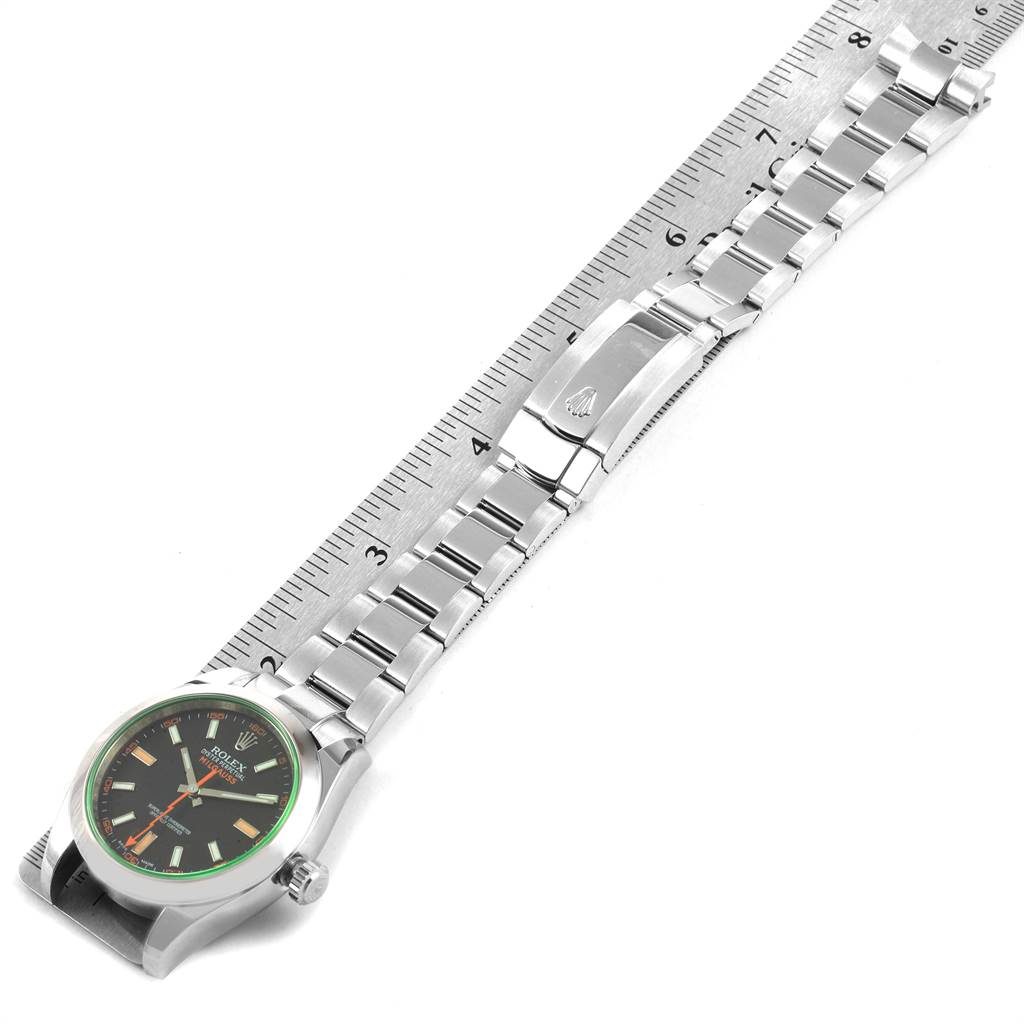 The image shows a horizontal view of a Rolex Milgauss 116400V Men's Stainless Steel Black Dial 116400V Men's Stainless Steel Black Dial watch displaying its face and full metal bracelet on a ruler.
