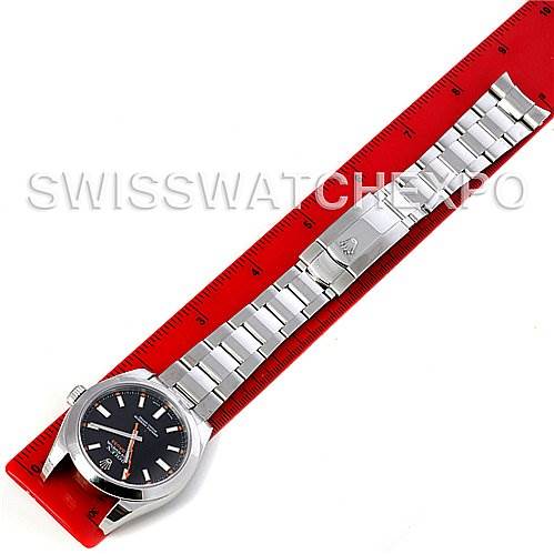 The image shows a top-down view of a Rolex Milgauss 116400BKSO Men's Stainless Steel Black Dial 116400BKSO Men's Stainless Steel Black Dial watch, including its dial and full bracelet laid out next to a red ruler.
