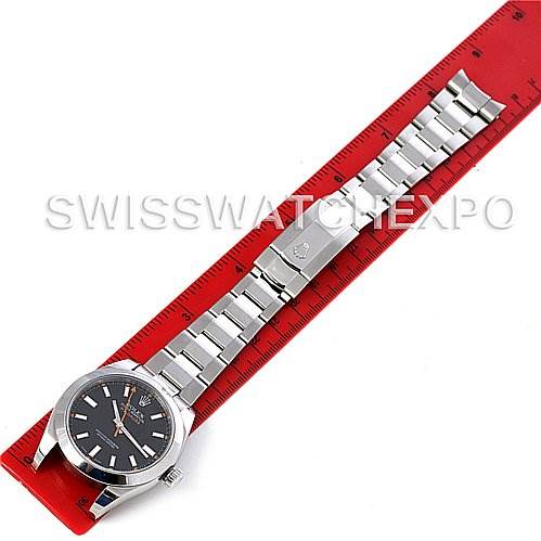 This image shows a top-down view of a Rolex Milgauss 116400BKSO Men's Stainless Steel Black Dial 116400BKSO Men's Stainless Steel Black Dial watch laid along a red ruler.