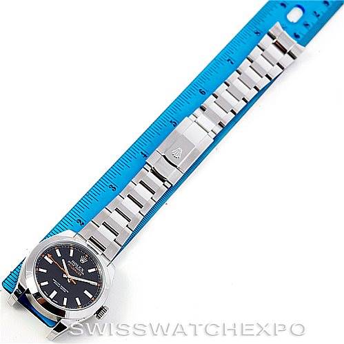 This image shows a Rolex Milgauss 116400 Men's Stainless Steel Black Dial 116400 Men's Stainless Steel Black Dial watch laid flat next to a blue ruler, including the face, bracelet, and clasp.