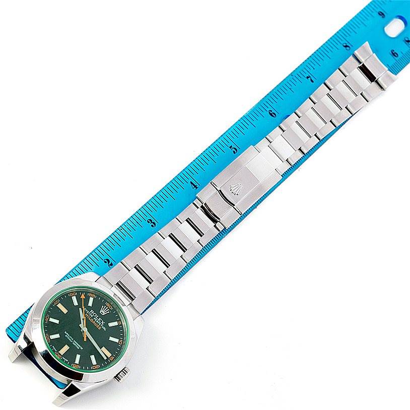 The image shows a top-down view of a Rolex Milgauss 116400V Men's Stainless Steel Black Dial 116400V Men's Stainless Steel Black Dial watch with its stainless steel bracelet measured against a blue ruler.