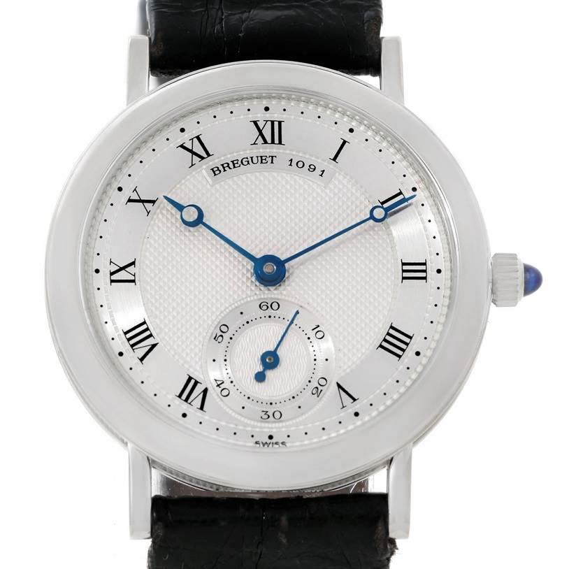 The Breguet Classique 3210 White Gold Silver Dial 3210 White Gold Silver Dial model watch is shown from a front angle, highlighting its face, Roman numerals, blue hands, and leather strap.