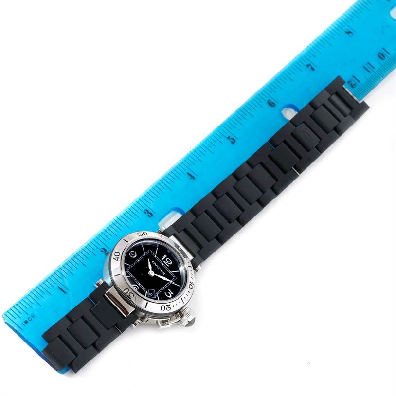 The image shows a Cartier Pasha W3140003 Women's Stainless Steel Black Dial W3140003 Women's Stainless Steel Black Dial watch with a black strap and a bezel, positioned alongside a blue ruler for scale.
