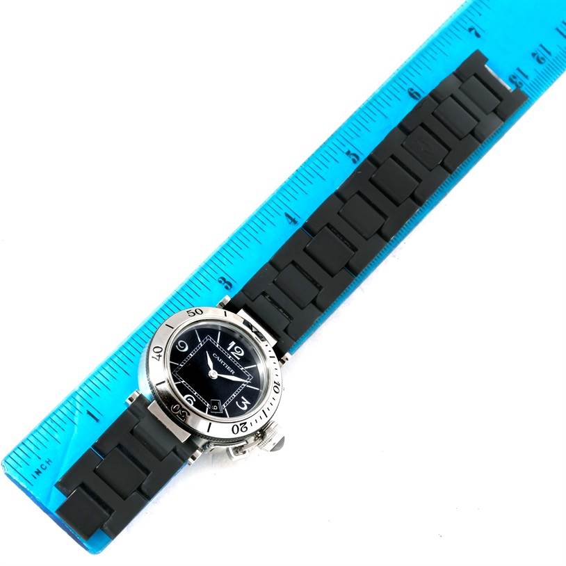 The Cartier Pasha W3140003 Women's Stainless Steel Black Dial W3140003 Women's Stainless Steel Black Dial watch is shown from a top-down angle, displaying the face, bezel, and strap alongside a ruler for scale.