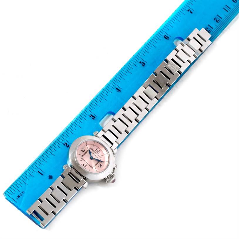 The image shows a Cartier Pasha W3140008 Women
s Stainless Steel Pink Dial W3140008 Women
s Stainless Steel Pink Dial watch laid flat against a blue ruler, displaying its face and metal strap.
