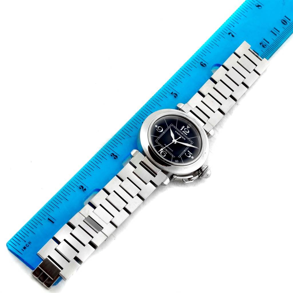 The Cartier Pasha W31076M7 Women's Stainless Steel Black Dial W31076M7 Women's Stainless Steel Black Dial watch is shown from a top-down angle, with the full watch band laid out alongside a ruler.