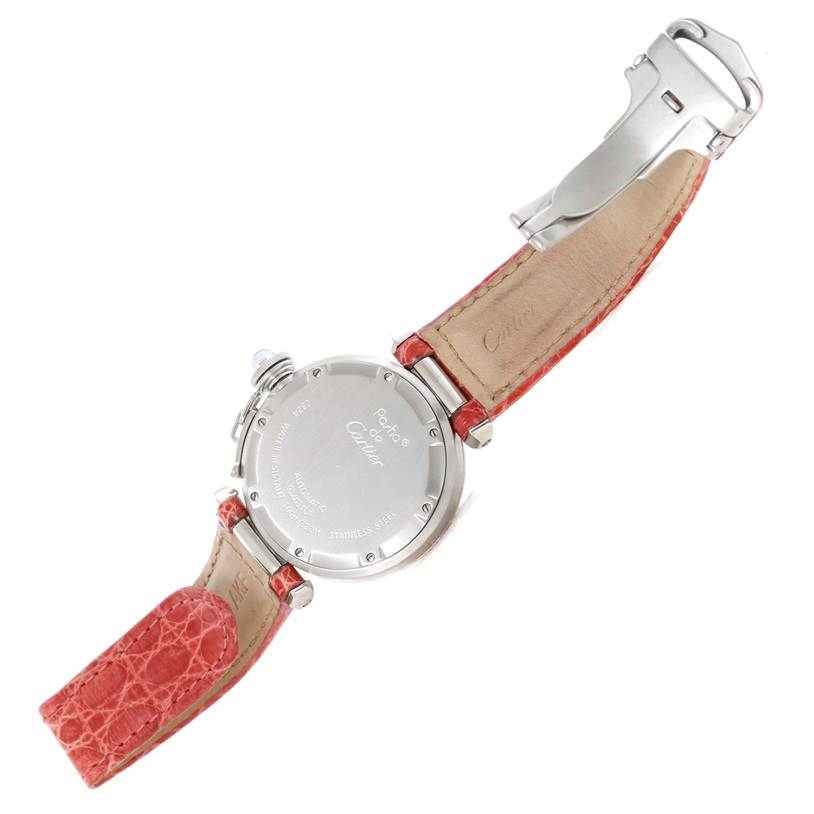 The image shows the back of the Cartier Pasha W3108199 Women's Stainless Steel Pink Dial W3108199 Women's Stainless Steel Pink Dial watch with an open red leather strap and visible buckle.