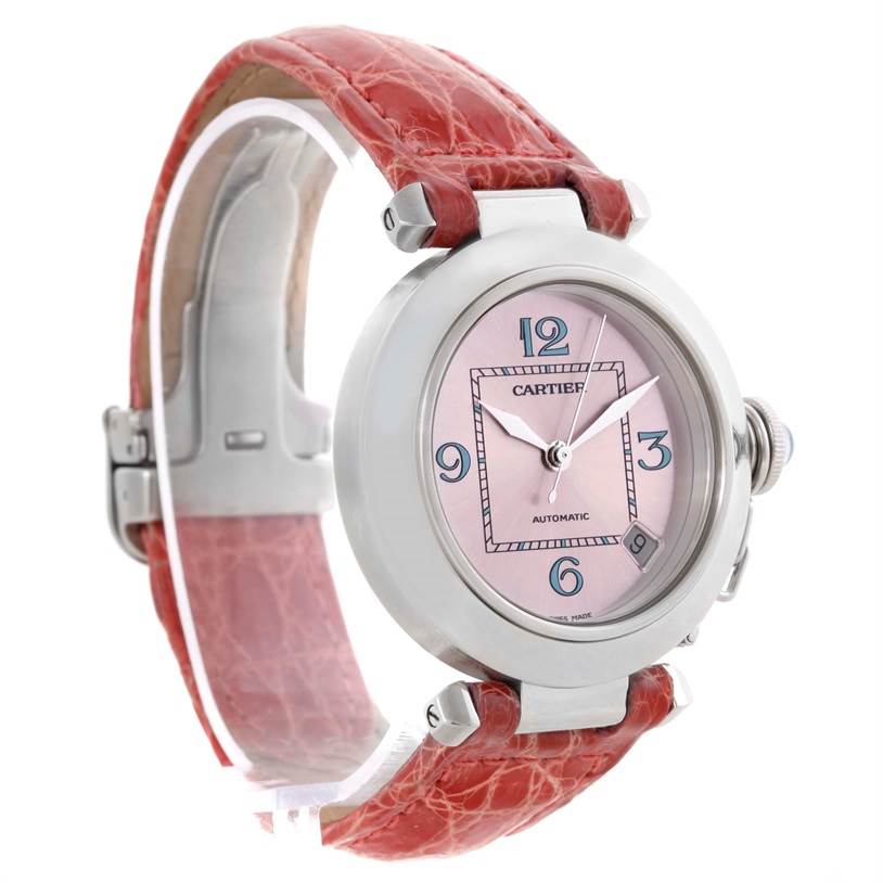 This Cartier Pasha W3108199 Women's Stainless Steel Pink Dial W3108199 Women's Stainless Steel Pink Dial watch is shown from a side angle featuring its pink dial, silver casing, and red leather strap.