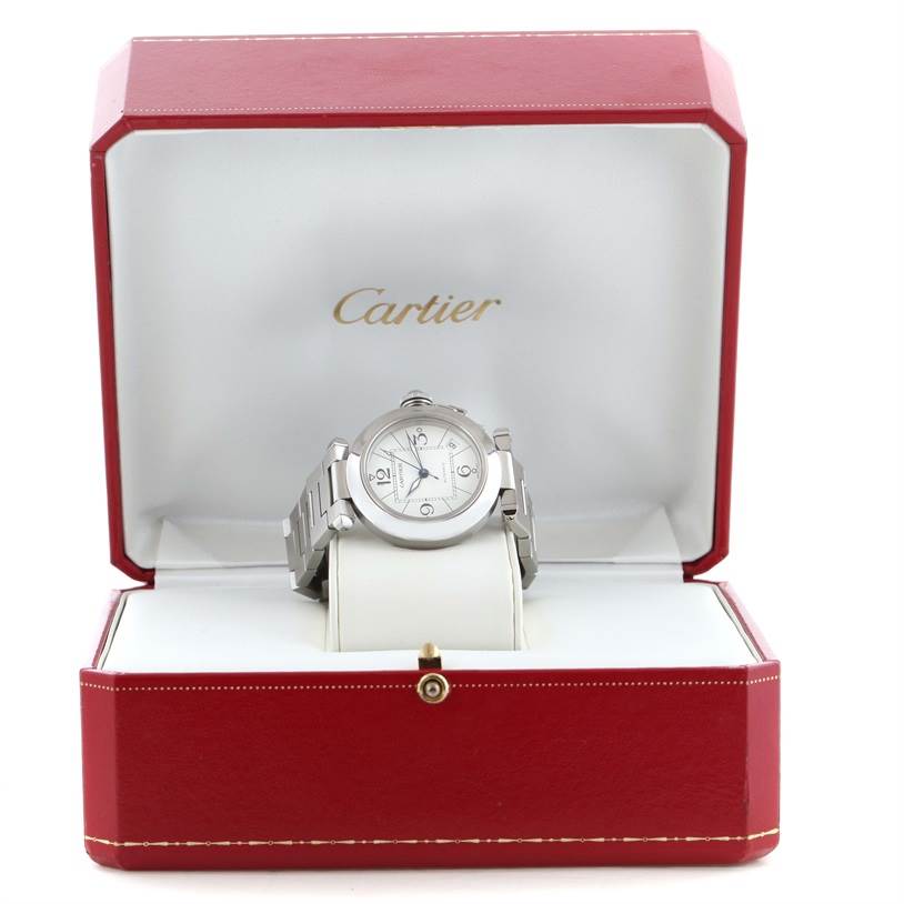 The Cartier Pasha W31074M7 Women's Stainless Steel White Dial W31074M7 Women's Stainless Steel White Dial watch is shown at a front angle, displayed inside its red and white presentation box.