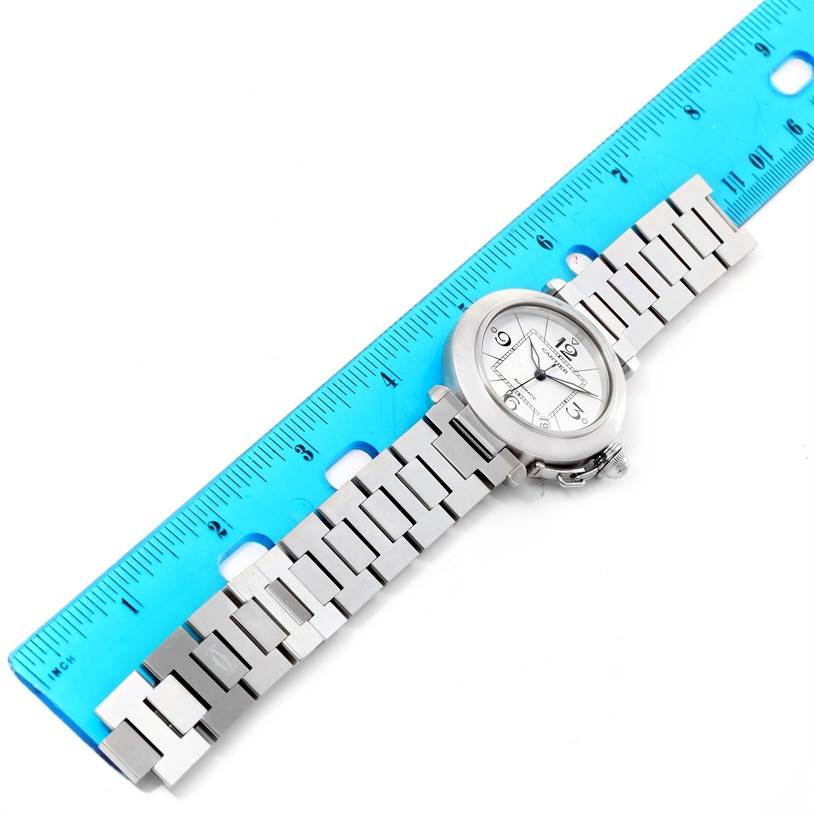 The image shows a top-down view of a Cartier Pasha W31074M7 Women's Stainless Steel White Dial W31074M7 Women's Stainless Steel White Dial watch, aligned next to a blue ruler for size reference.