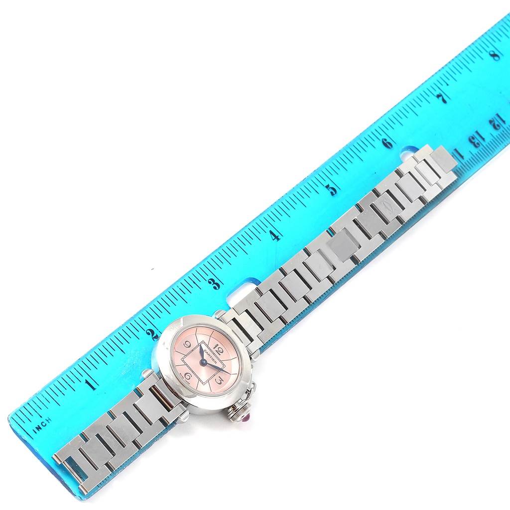 This image shows a Cartier Pasha W3140008 Women's Stainless Steel Pink Dial W3140008 Women's Stainless Steel Pink Dial watch laid flat next to a ruler, highlighting the watch face and metal bracelet.