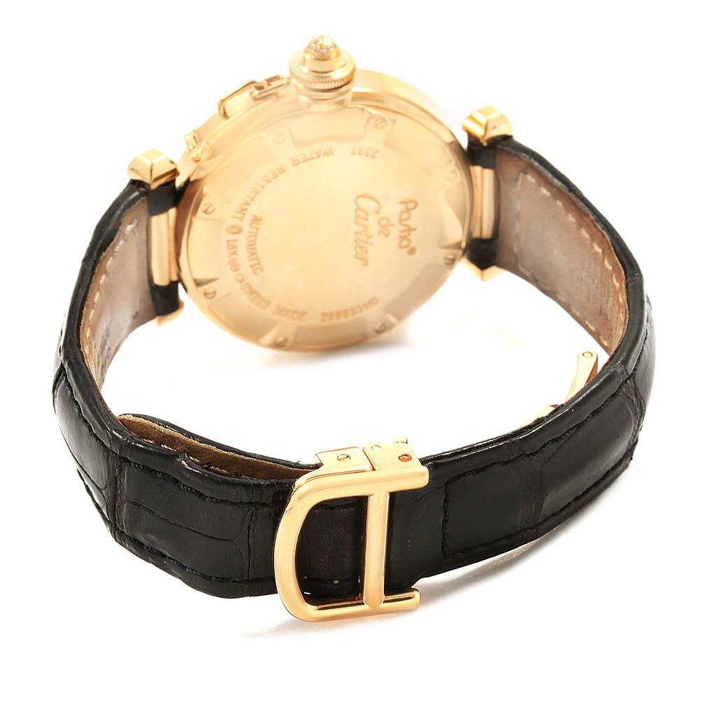 The image shows the back case and leather strap of a Pasha de Cartier watch, highlighting its golden clasp and case details.