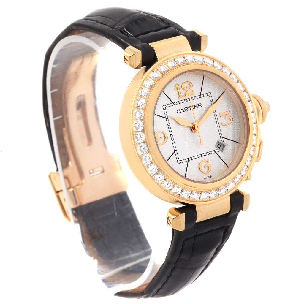 The Cartier Pasha Women's Yellow Gold Silver Dial Women's Yellow Gold Silver Dial watch is shown at an oblique angle, highlighting the diamond-studded bezel, gold case, and black leather strap.