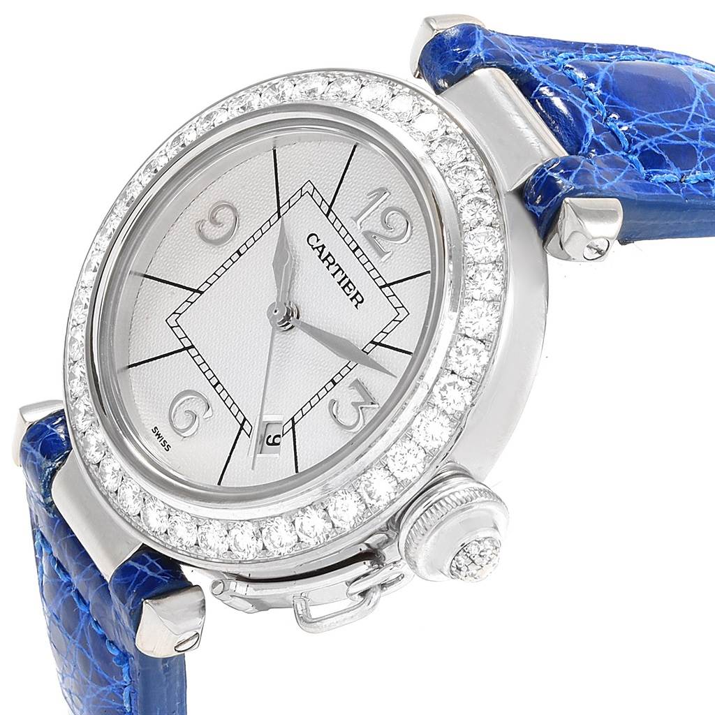 This image shows a close-up, angled view of the Cartier Pasha Women's White Gold Silver Dial Women's White Gold Silver Dial watch, highlighting its face, bezel, and blue strap.