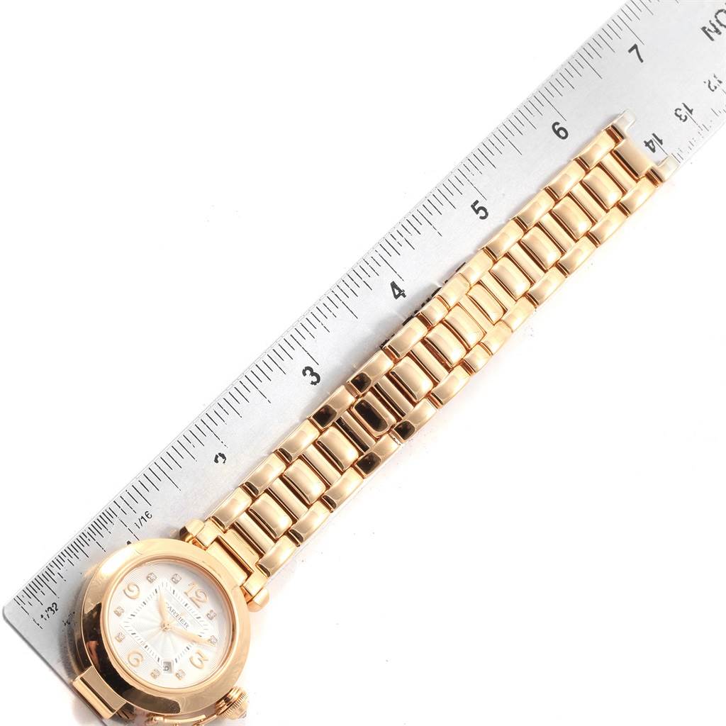 The image shows an overhead view of a Cartier Pasha 2397 Women's Yellow Gold Silver Dial 2397 Women's Yellow Gold Silver Dial watch, highlighting its gold strap and dial next to a ruler for scale.