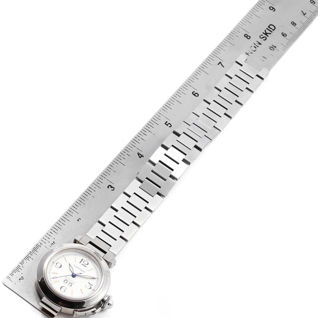 The image shows the face and bracelet of a Cartier Pasha W31044M7 Men's Stainless Steel White Dial W31044M7 Men's Stainless Steel White Dial watch next to a ruler for measurement.