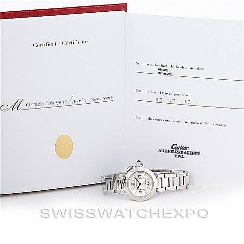 The image shows a Cartier Pasha W31043M7 Women
s Stainless Steel Silver Dial W31043M7 Women
s Stainless Steel Silver Dial watch with its certificate and an open booklet/card angled from the front.