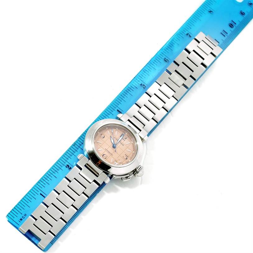 The image shows a Cartier Pasha W31023M7 Stainless Steel Pink Dial W31023M7 Stainless Steel Pink Dial watch, viewed from above, placed on a blue ruler for scale.
