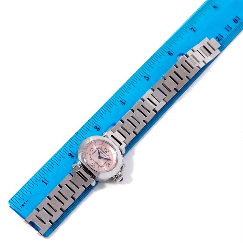 The Cartier Pasha W3140008 Women
s Stainless Steel Pink Dial W3140008 Women
s Stainless Steel Pink Dial watch is displayed flat against a blue ruler, showing its full bracelet length and face.